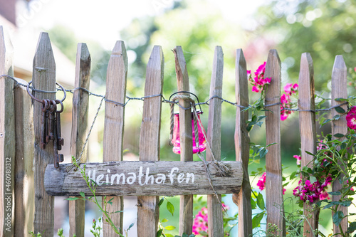 Wooden sign and old key ring hanging on rustic fence photo
