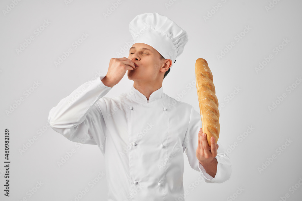 a man in chef's clothes with a baguette in the hands of a gourmet restaurants a man in chef's clothes with a baguette in the hands of a gourmet restaurants
