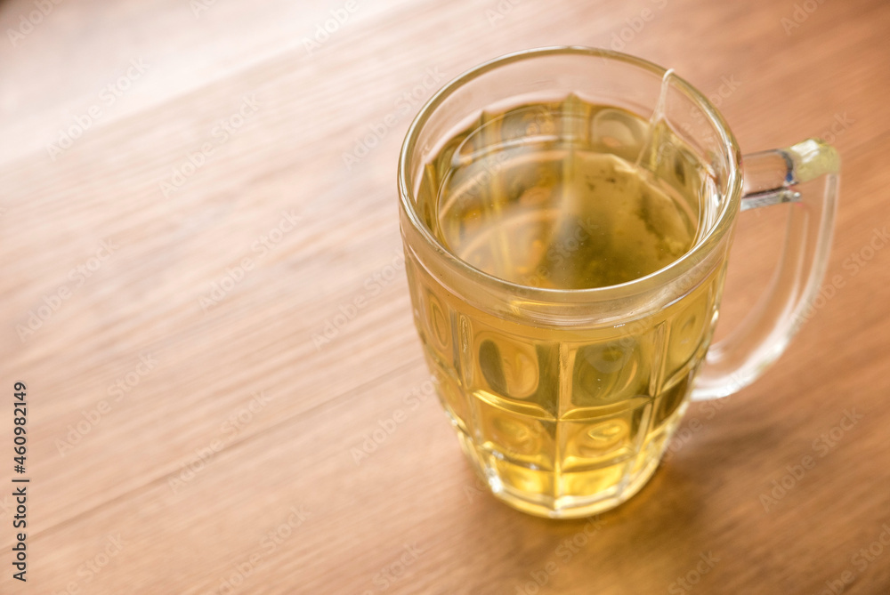 Selective focus of a glass of tea with a tea bag on a wooden background. Selective focus of a glass of tea with a tea bag on a wooden background.