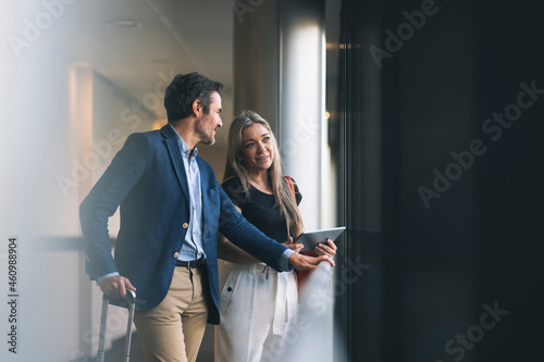 Smiling businesswoman and male professional talking in hotel