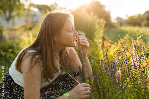 Woman smelling hyssop flower in back yard photo