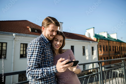 Young couple sharing mobile phone at rooftop photo