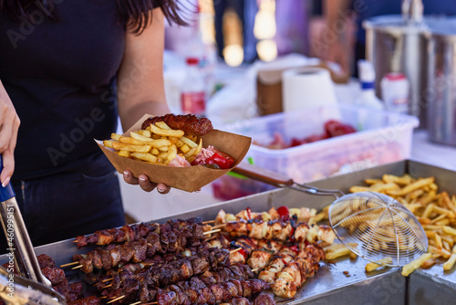 Grilled kebab cooking on metal skewer. Roasted meat cooked at barbecue. BBQ fresh beef meat chop slices. Traditional eastern dish  shish kebab. Grill on charcoal and flame  picnic  street food