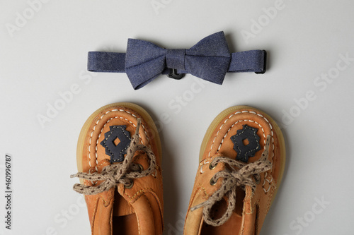 Fotografie, Obraz Baby shoes and bow tie on light gray background