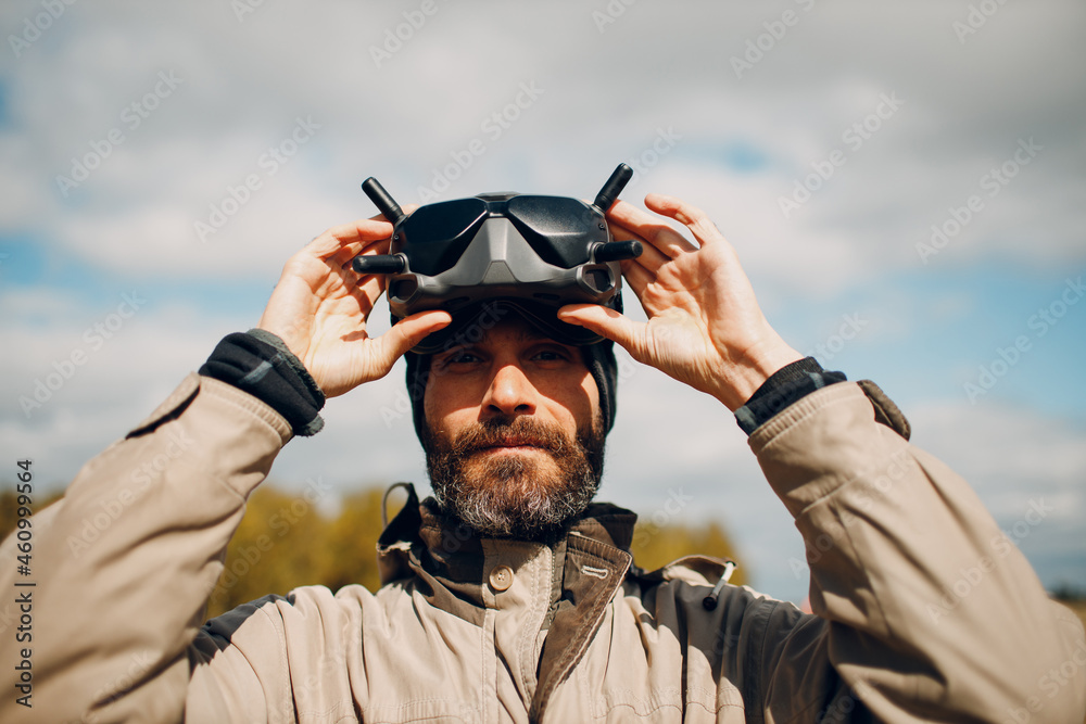 Man controlling fpv quadcopter drone for aerial photography and videography with goggles antenna remote controller. Man controlling fpv quadcopter drone for aerial photography and videography with goggles antenna remote controller.
