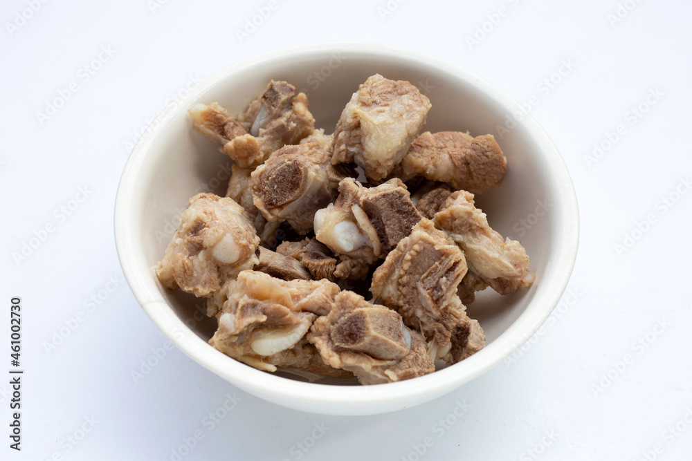 Boiled pork ribs in white bowl on white background. Boiled pork ribs in white bowl on white background.