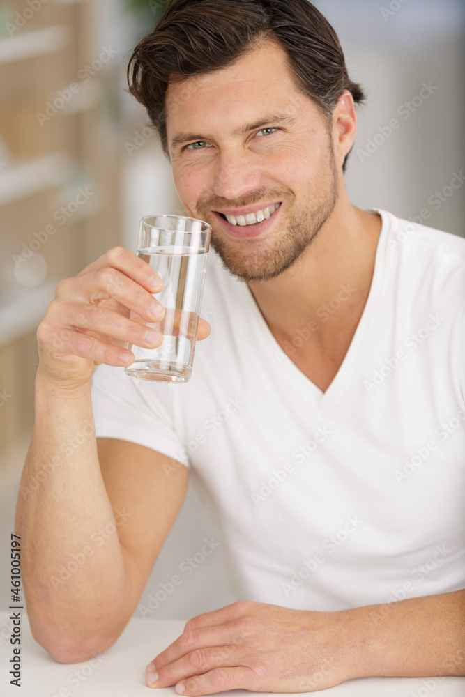 happy man drinking water in kitchen happy man drinking water in kitchen