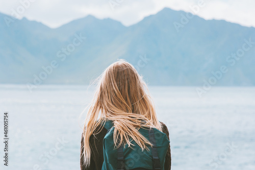 Travel in Norway globetrotter woman with backpack looking at mountains view alone outdoor active vacations adventure lifestyle solo trip photo