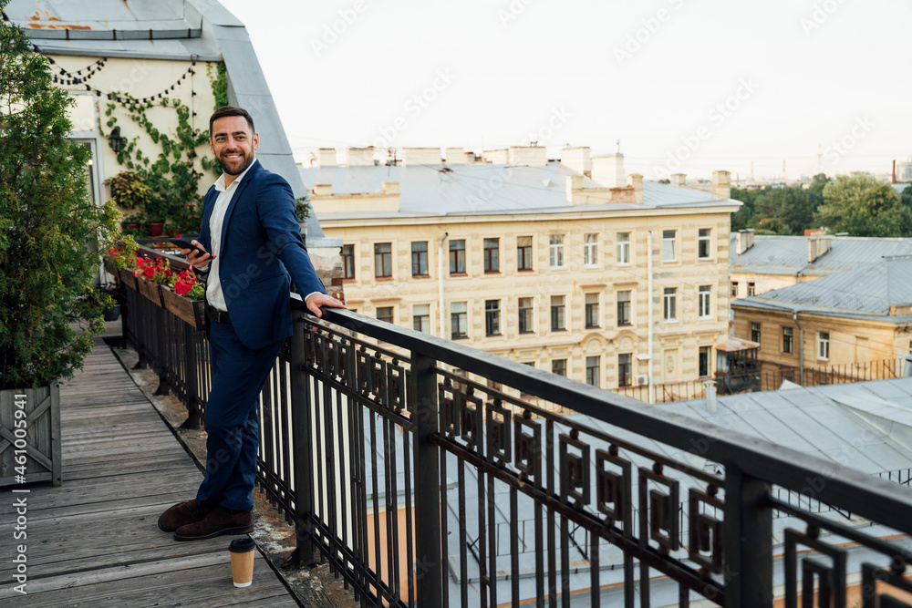 Male professional standing near railing in office balcony Male professional standing near railing in office balcony