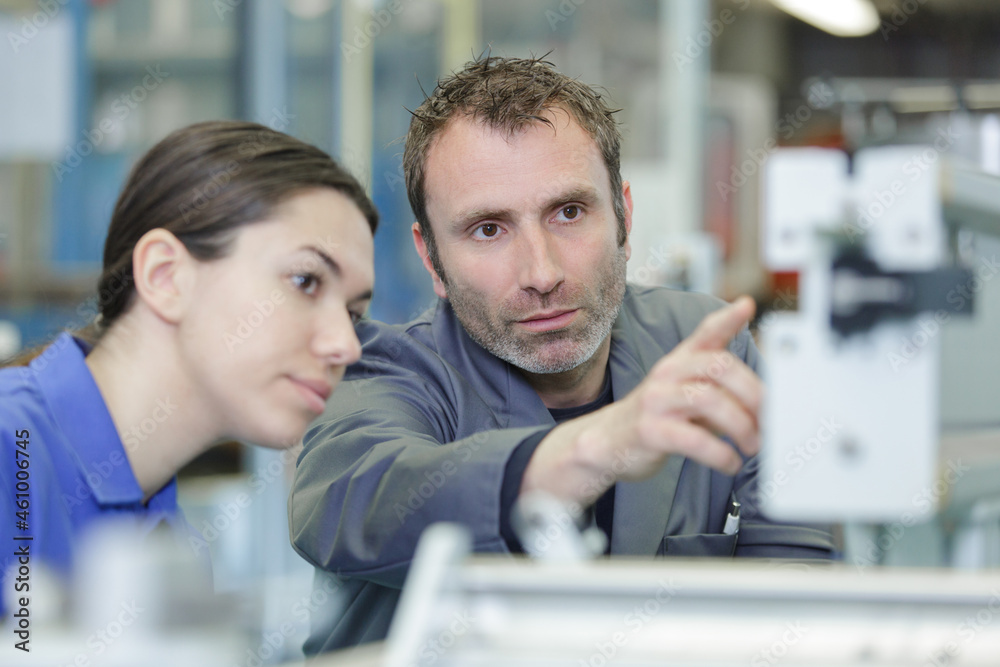 Fototapeta premium engineer teaching apprentice to use factory machine