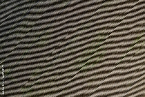 Aerial top down view of cultivated agricultural land with rows pattern in the plowed field