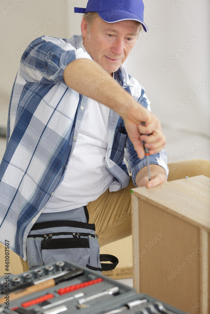 mature carpenter finishing a furniture