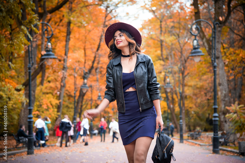 Young fashion woman in casual clothes and black leather jacket over urban city background autumn portrait. Hipster girl posing at street. Fashionable long hair model in elegant autumn clothes. hat. Young fashion woman in casual clothes and black leather jacket over urban city background autumn portrait. Hipster girl posing at street. Fashionable long hair model in elegant autumn clothes. hat.