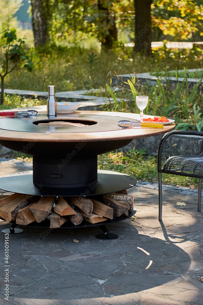 Kettle Grill Pit with Cast Iron Grid with flames . Round table-cooking surface. Hot BBQ on Backyard