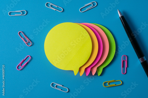 Top view of blank post-it note on blue background and different objects. Minimal flat lay style.