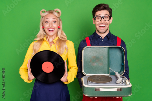 Photo of young excited couple music vintage vinyl player party audio isolated over green color background
