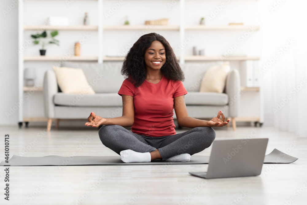 African American Woman Meditating In Front Of Laptop At Home