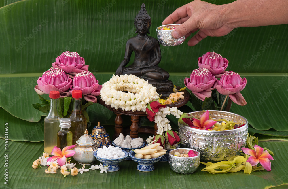 Jasmine garland and Colorful flower in water bowls decorating and scented water, perfume, marly limestone, pipe gun on Banana leaf for Songkran Festival or Thai New Year.