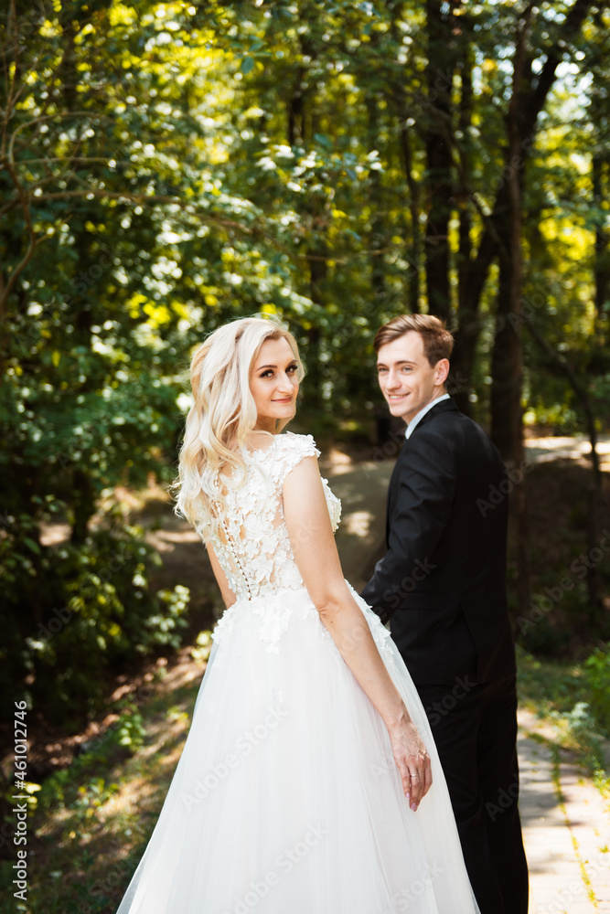 Bride and groom at wedding day walking outdoors on summer nature. Stylish and beautiful. Bridal couple. Loving wedding couple outdoor Bride and groom at wedding day walking outdoors on summer nature. Stylish and beautiful. Bridal couple. Loving wedding couple outdoor