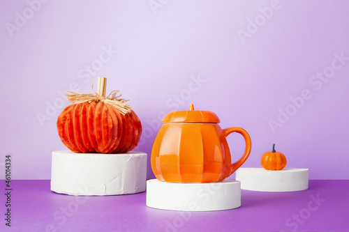 Halloween celebration. Various decarative pumpkins on white round podiums on purple background photo