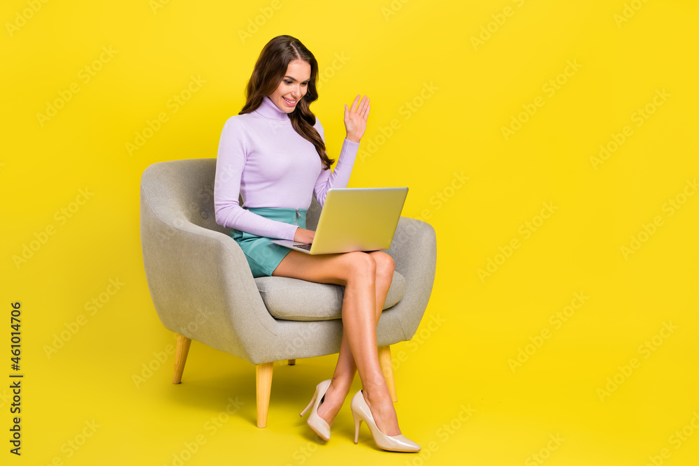 Full length photo of charming positive girl arm palm waving hi video conversation isolated on yellow color background Full length photo of charming positive girl arm palm waving hi video conversation isolated on yellow color background