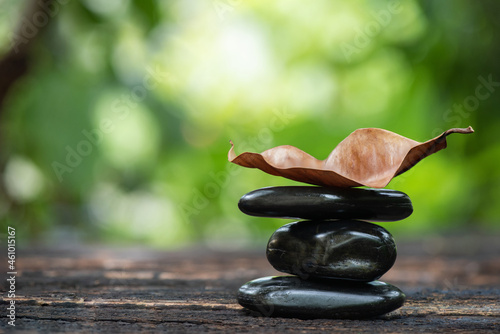 Canvas Print Dried leaf and zen stones on nature bokeh background.