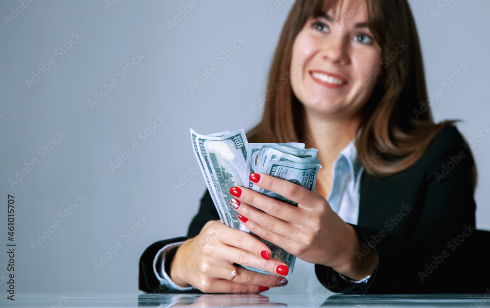 Conceptual image: Money is best motivation. Portrait of very happy beautiful business woman with US Dollar bills and about shopping and future plans. Selective focus on the money.