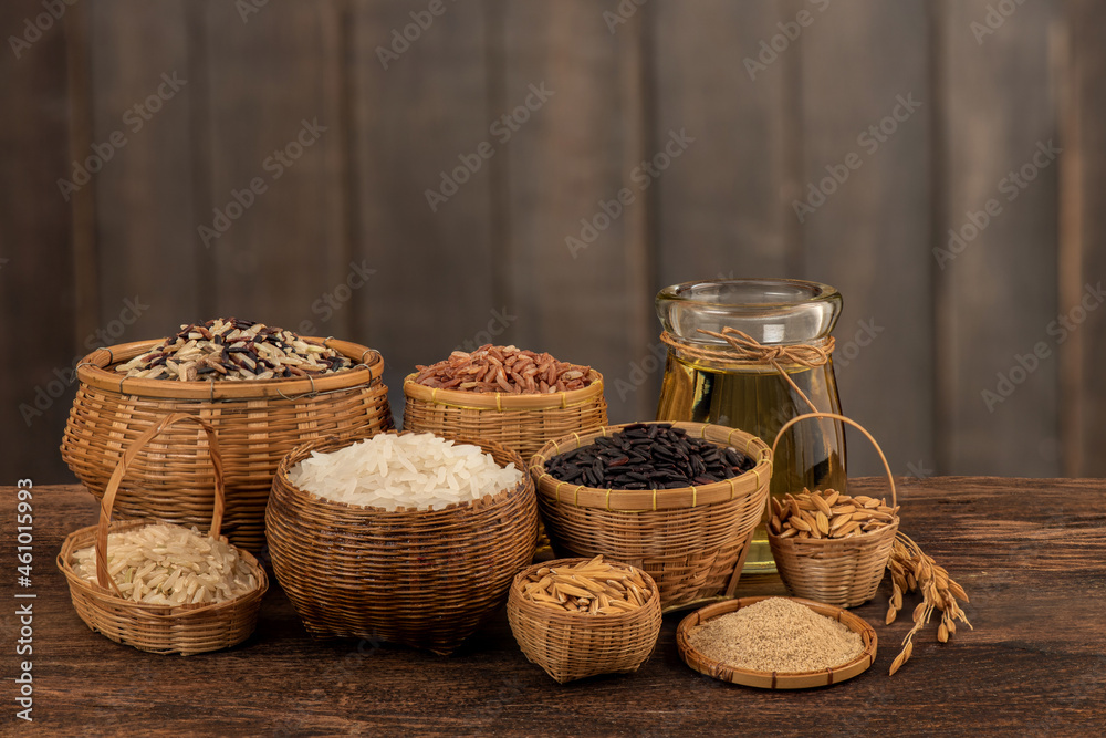 Red,white,brown jasmine rice ,rice berry seeds and oil on an old wooden background.