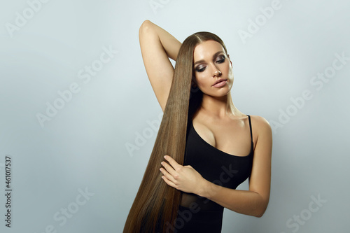 Young beautiful woman with long dark shiny hair. Hair care. Advertising of hair products. Hair cosmetics.