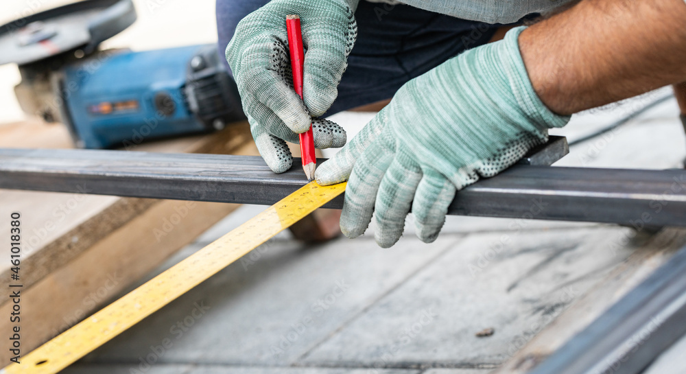man measures metal with a ruler for cutting man measures metal with a ruler for cutting