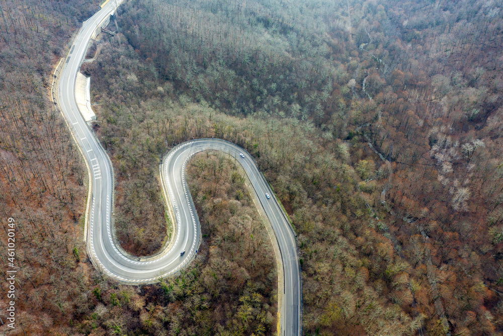 Aerial view of mountain road between Vozrozhdenie and Mikhaylovsky Pereval villages on sunny winter day. Krasnodar Krai, Russia.