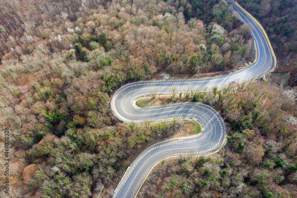 Top view of mountain road between Vozrozhdenie and Mikhaylovsky Pereval villages on sunny winter day. Krasnodar Krai, Russia. Top view of mountain road between Vozrozhdenie and Mikhaylovsky Pereval villages on sunny winter day. Krasnodar Krai, Russia.