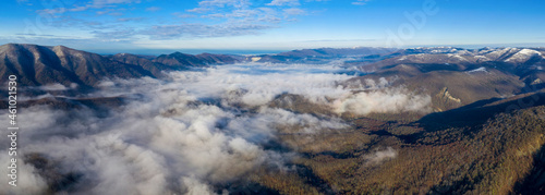 Panoramic aerial view of covered with fog mountain valley close to Gelendzhik on sunny winter day. Krasnodar Krai  Russia.