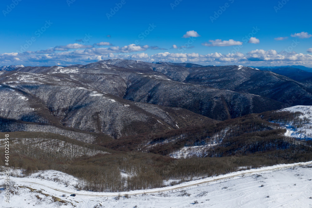 Aerial view of covered with snow Caucasian mountains nearby Gelendzhik on sunny winter day. Wuthering Heights, Krasnodar Krai, Russia.