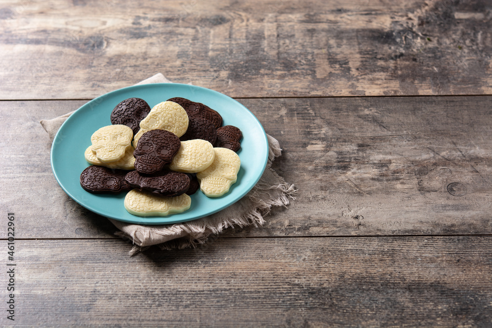 Fototapeta premium Chocolate Mexican skulls in plate on wooden table