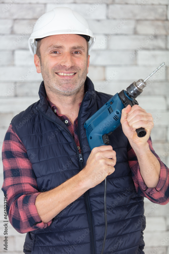 selective focus of happy mature man holding hammer drill