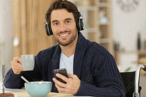 disable man smiling while holding a bowl of cereals