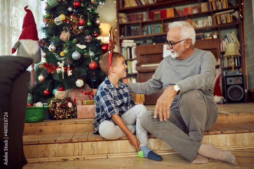 Happy grandfather and grandson talk while spending Christmas together at home. © Drazen