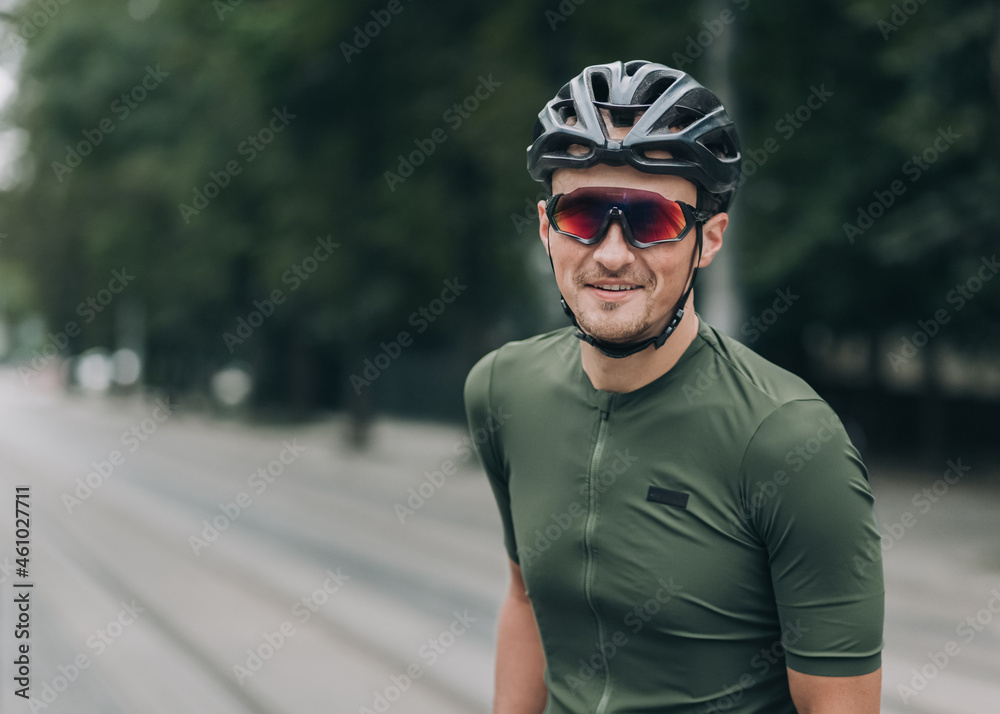 Man in helmet and glasses sitting on bike and smiling Man in helmet and glasses sitting on bike and smiling