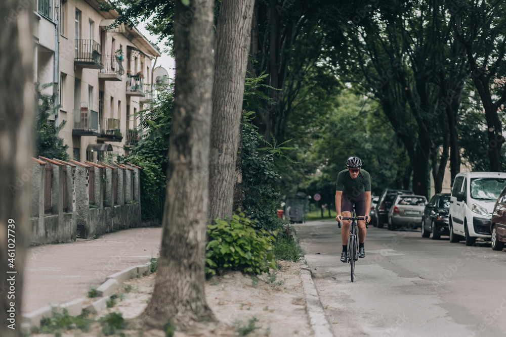 Man in helmet using bike for cycling on asphalt road