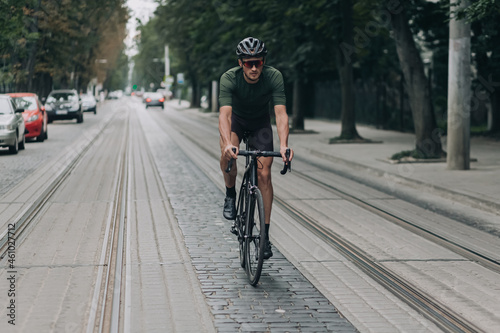 Man in helmet and glasses using bike for riding on street