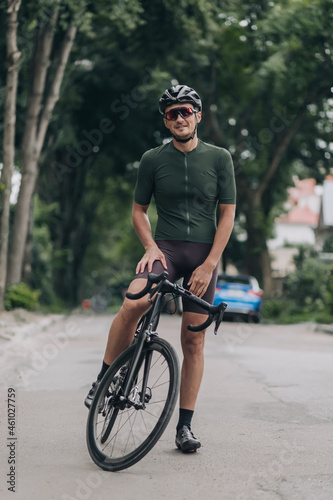 Man in sportswear smiling on camera while sitting on bike