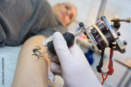 Tattoo being performed on woman s arm