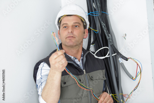 worker wiring cables inside house under construction