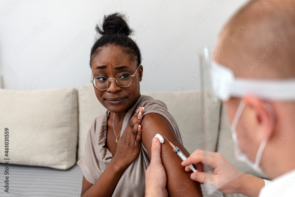 Professional doctor or nurse giving flu or COVID-19 injection to patient. Man in medical face mask getting antiviral vaccine at hospital or health center during vaccination and immunization campaign. Professional doctor or nurse giving flu or COVID-19 injection to patient. Man in medical face mask getting antiviral vaccine at hospital or health center during vaccination and immunization campaign.