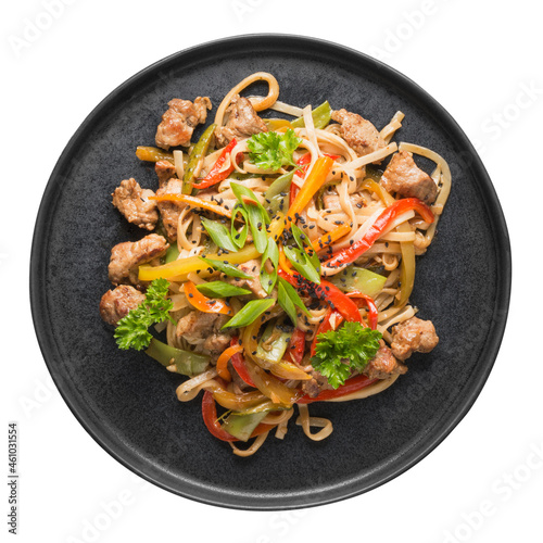 Stir fry udon noodles with pork and colorful vegetables in black platter isolated on white background. Asian cuisine. Top view.