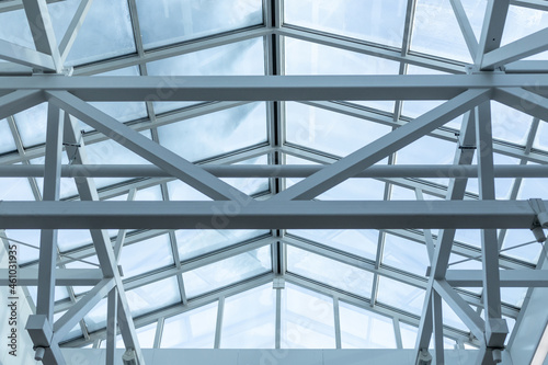 Steel frame of the glazed roof of a warehouse, shopping or office center. The ceilings are made of metal beams interconnected by welding to maintain rigidity. photo
