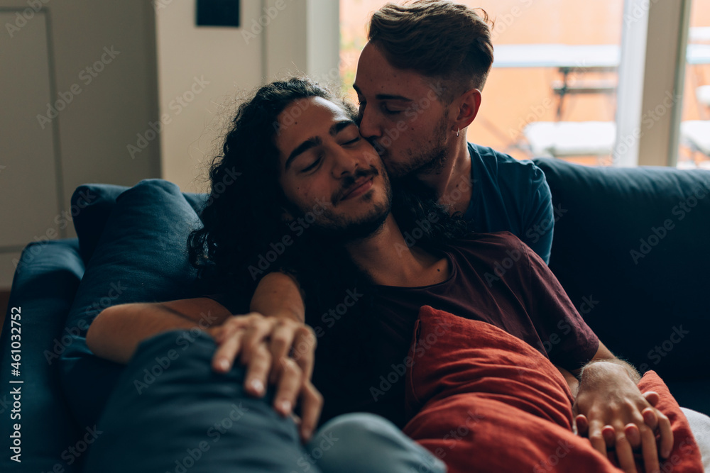 gay couple in love relaxing and bonding on sofa - hug and cuddle with  closed eyes Stock Photo | Adobe Stock