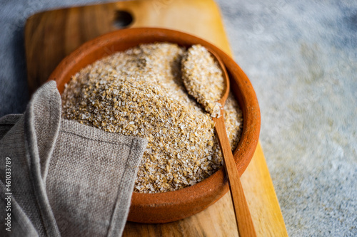 Overhead view of a bowl of milled oatmeal bran and a napkin