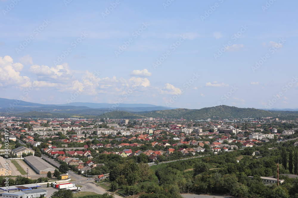 Fototapeta premium aerial view of the city. Scenic view of the town in the mountains on a cloudy summer day.